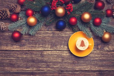 Noel ağacı şeklinde ahşap bir masa üzerinde sıcak cappuccino 