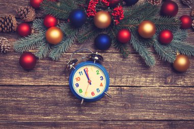 Çamın dalları ahşap masa üzerinde yakınındaki çalar saat.