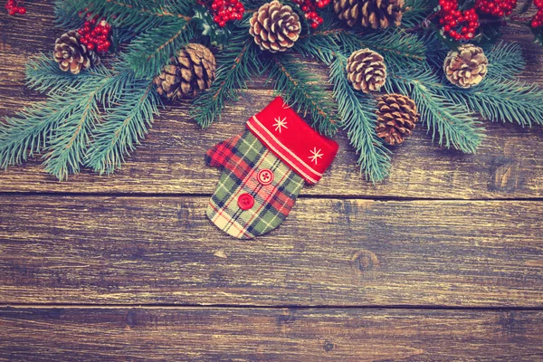 Mitten on a table near pinecones and branches — Stock Photo, Image