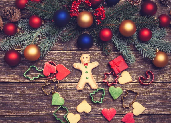 Gingerbread man nearPine branch on a wooden table. — Stock Photo, Image