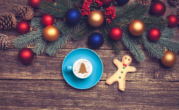 Горячий капучино с рождественской елкой на деревянном столе рядом — стоковое фото