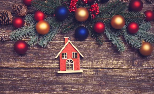 Home toy near pine branches and toys on a table — Stock Photo, Image