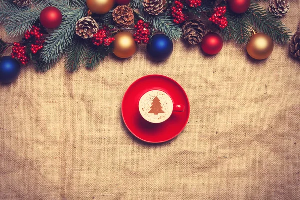 Hot cappuccino with christmas tree shape on a table near pine br — Stock Photo, Image