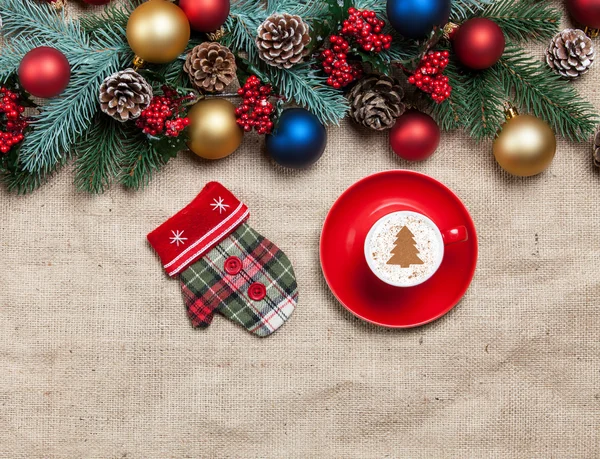 Cappuccino caldo a forma di albero di Natale e mitten su un tavolo n — Foto Stock