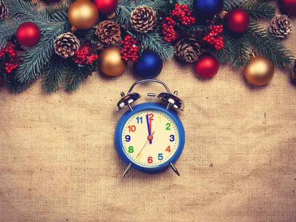 Alarm clock near Pine branches on a table. — Stock Photo, Image