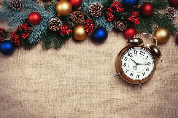 Reloj despertador cerca de ramas de pino en una mesa . — Foto de Stock