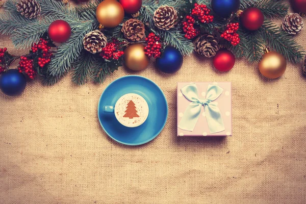 Hot cappuccino with christmas tree shape on a table near pine br — Stock Photo, Image