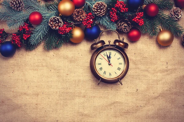 Alarm clock near Pine branches on a table. — Stock Photo, Image