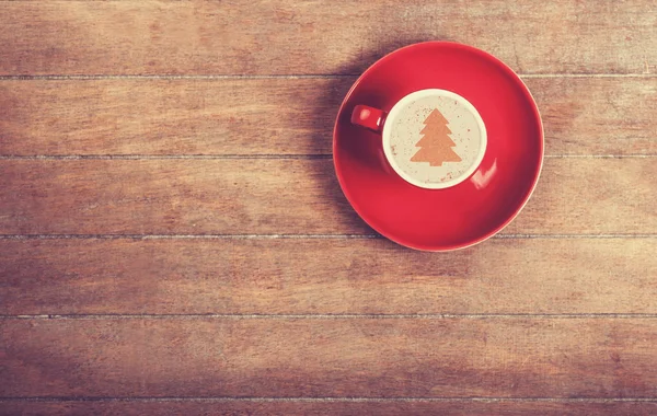 Cappuccino with christmas tree shape on a wooden table. — Stock Photo, Image