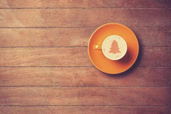 Cappuccino mit Christbaumform auf einem Holztisch. — Stockfoto