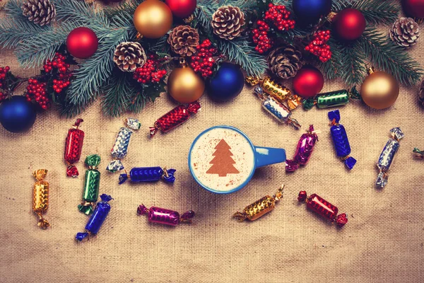 Hot cappuccino with christmas tree shape on a table near pine br — Stock Photo, Image