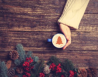 Kadın holding fincan kahve krem Noel ağacına bir tabl ile