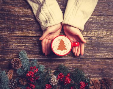 Kadın holding fincan kahve krem Noel ağacına bir tabl ile