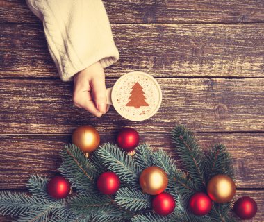 Kadın holding fincan kahve krem Noel ağacına bir tabl ile