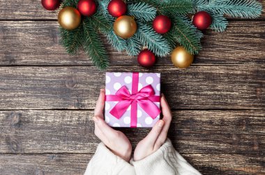 Hediye kutusu bir tablo üzerinde tutan kadın.