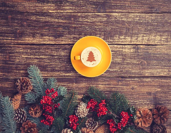 Kuppi kahvia kerma joulukuusi pöydällä . — kuvapankkivalokuva