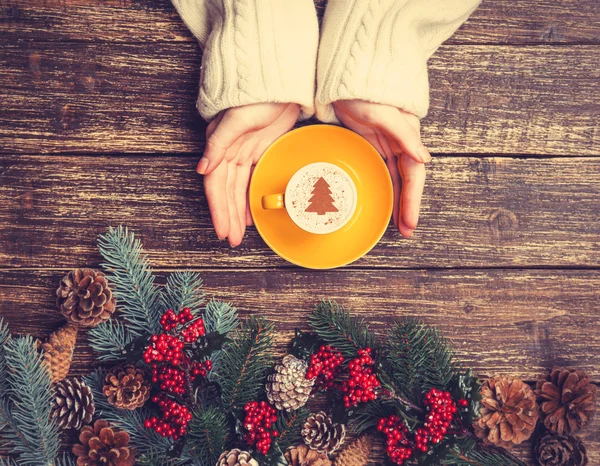 女性控股杯加奶油圣诞树在桌子上的咖啡 — 图库照片
