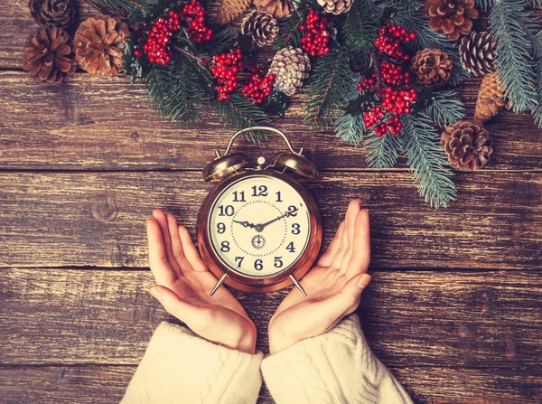 Female holding alarm clock on a table. — Stock Photo, Image