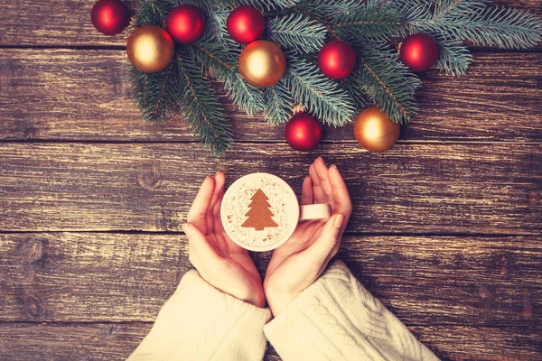 Kadın holding fincan kahve krem Noel ağacına bir tabl ile — Stok fotoğraf