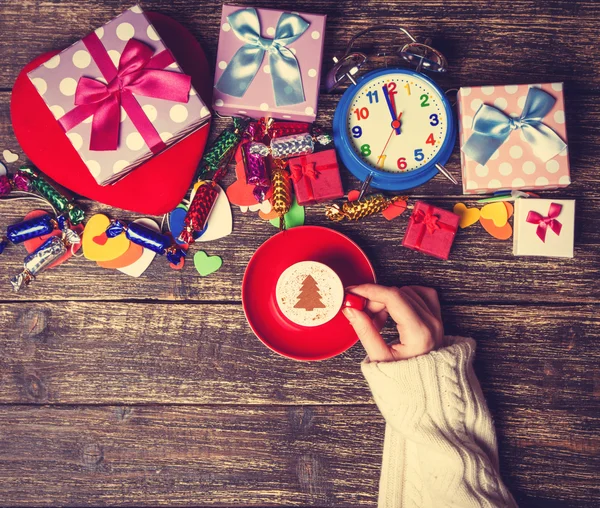 Femme tenant tasse de café avec arbre de Noël crème sur une table — Photo