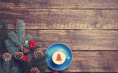 Noel ağacı şeklinde ahşap bir masa üzerinde sıcak cappuccino 