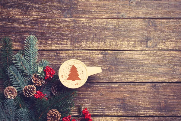 Hete cappuccino met kerstboom vorm op een houten tafel in de buurt van — Stockfoto