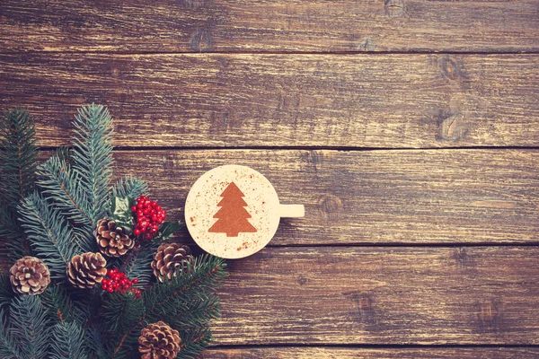 Hete cappuccino met kerstboom vorm op een houten tafel in de buurt van — Stockfoto