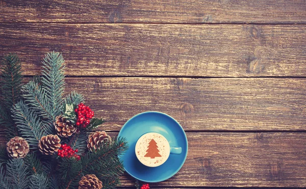 Hot cappuccino with christmas tree shape on a wooden table near — Stock Photo, Image