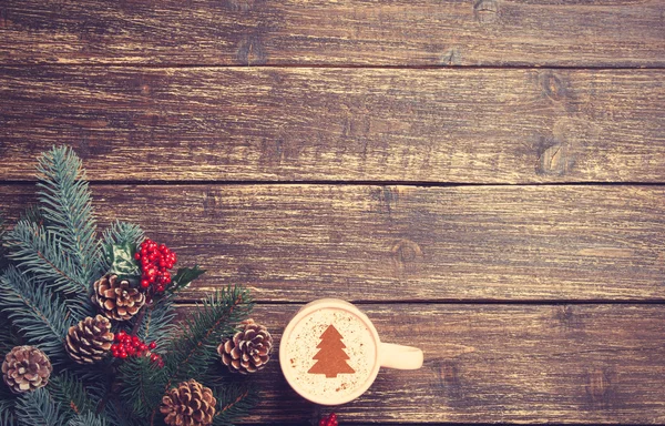 Cappuccino caliente con forma de árbol de Navidad en una mesa de madera cerca —  Fotos de Stock