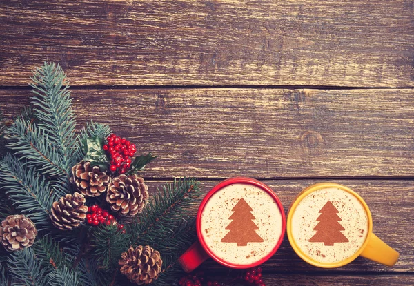 Dos copas con forma de árbol de Navidad cerca de la rama en una mesa de madera —  Fotos de Stock