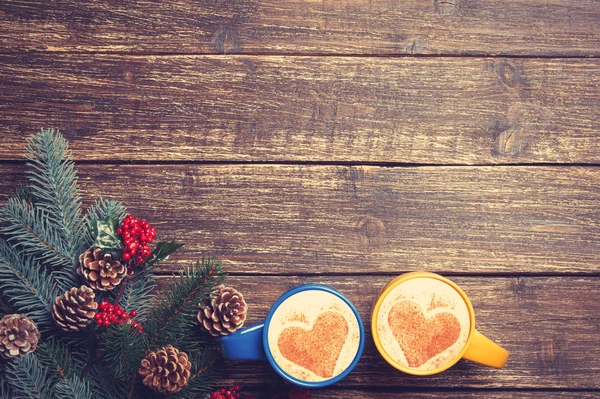 Two cups with heart shape near branch on a wooden table. — Stock Photo, Image