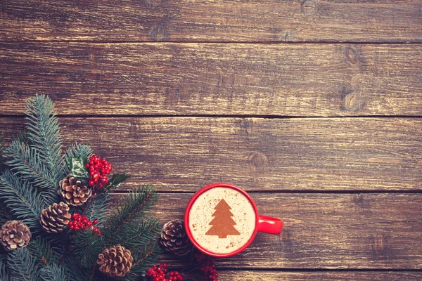 Cappuccino quente com forma de árvore de natal em uma mesa de madeira perto — Fotografia de Stock