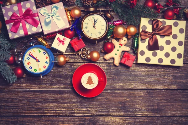 Gifts, cup of coffee and pine branch on a wooden table. — Stock Photo, Image