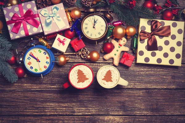 Cadeaux, deux tasses de café et branche de pin sur une table en bois . — Photo