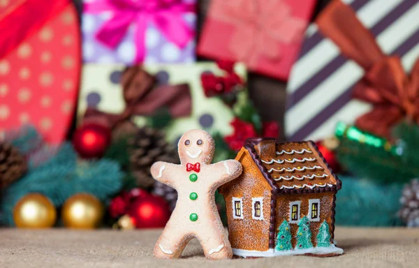 Casa de brinquedo e pão de gengibre com presentes de Natal no fundo — Fotografia de Stock