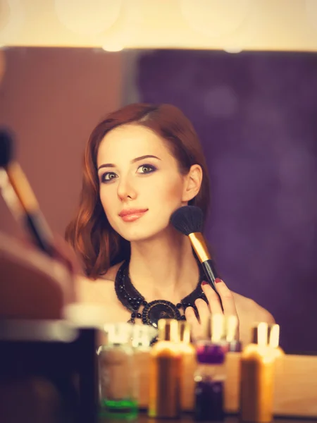 Beautiful redhead women appling makeup near mirror — Stock Photo, Image