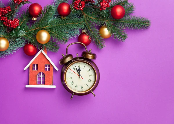 Alarm clock and toy house with pine branch — Stock Photo, Image