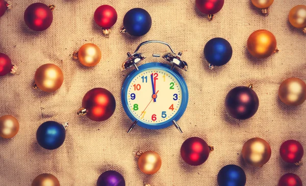 Retro alarm clock with gold, blue and red balls on jute backgrou — Stock Photo, Image