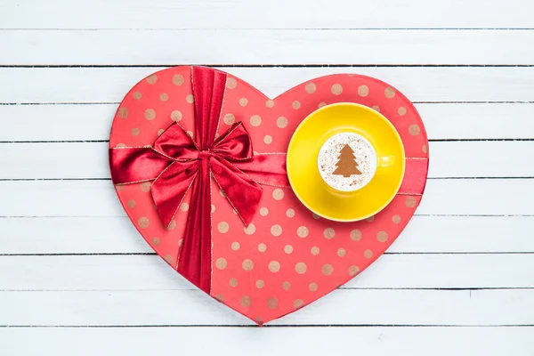 Gift box and cappuccino on white wooden table. — Stock Photo, Image