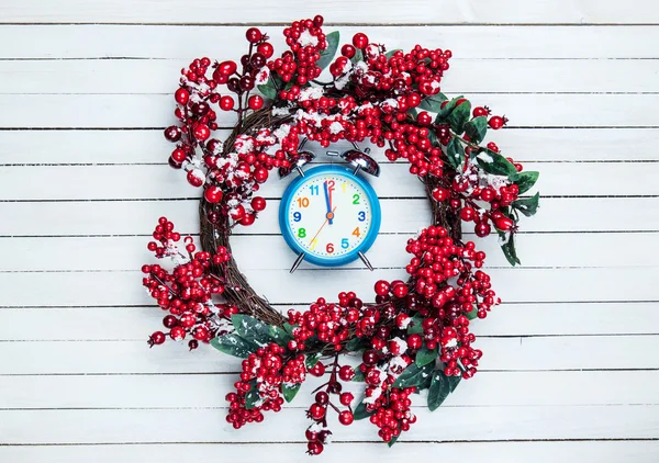 Stechpalme-Adventskranz mit Uhr auf Holztisch. — Stockfoto