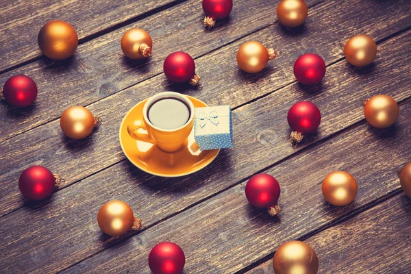 Copa de café y bolas de Navidad y regalo en la mesa de madera . —  Fotos de Stock