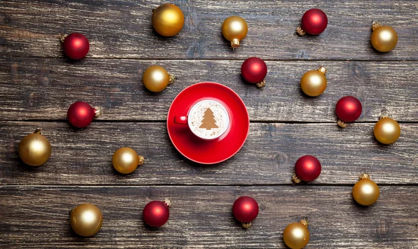 Cup of coffee and christmas balls on wooden table. — Stock Photo, Image