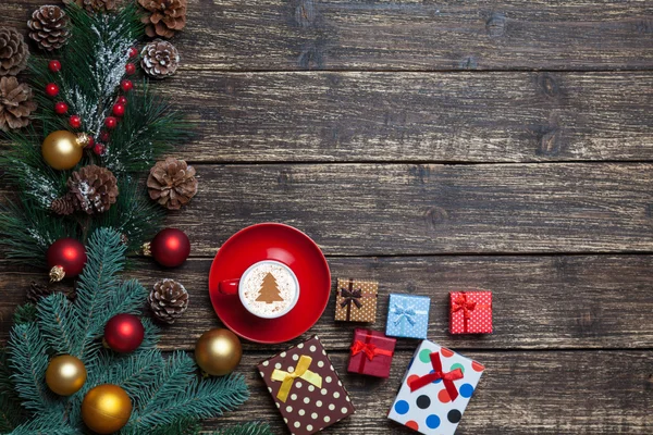 Cappuccino mit Christbaumform und Geschenk auf Holztisch. — Stockfoto