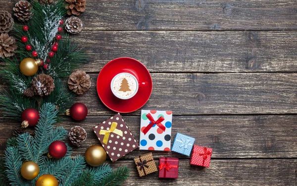 Cappuccino, karácsonyfa alakja és ajándékok a fa tábla. — Stock Fotó