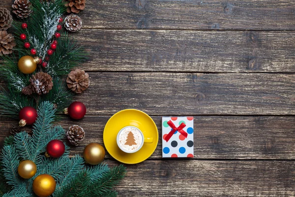 Cappuccino avec forme d'arbre de Noël et cadeau sur table en bois . — Photo