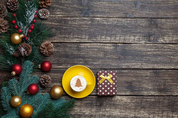 Капучино с рождественской елкой и подарком на деревянном столе . — стоковое фото