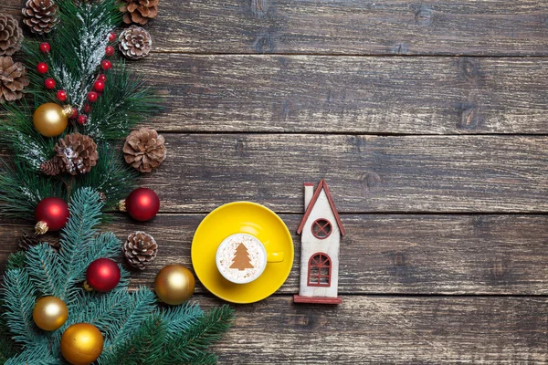 Cappuccino with christmas tree shape and toy house on wooden tab — Stock Photo, Image