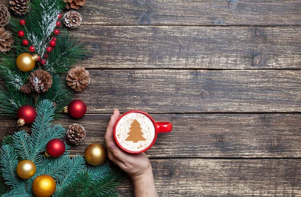 Cappuccino with christmas tree shape and male hand on wooden tab — Stock Photo, Image