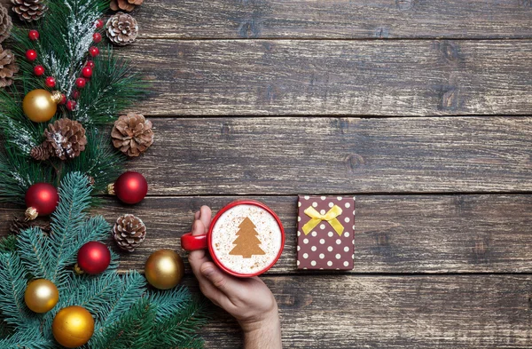 Cappuccino with christmas tree shape and pine branch on wooden t — Stock Photo, Image