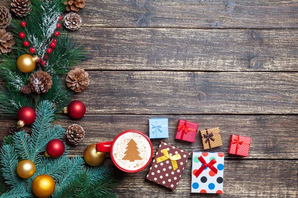 Cappuccino con albero di Natale sagomato e regalo su tavola in legno . — Foto Stock